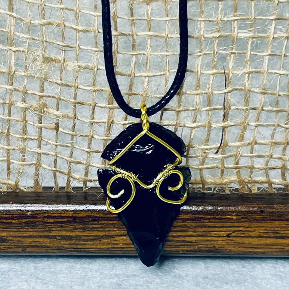 Handmade Wire-Wrapped Obsidian Arrowhead Pendant on faux leather cord necklace.
